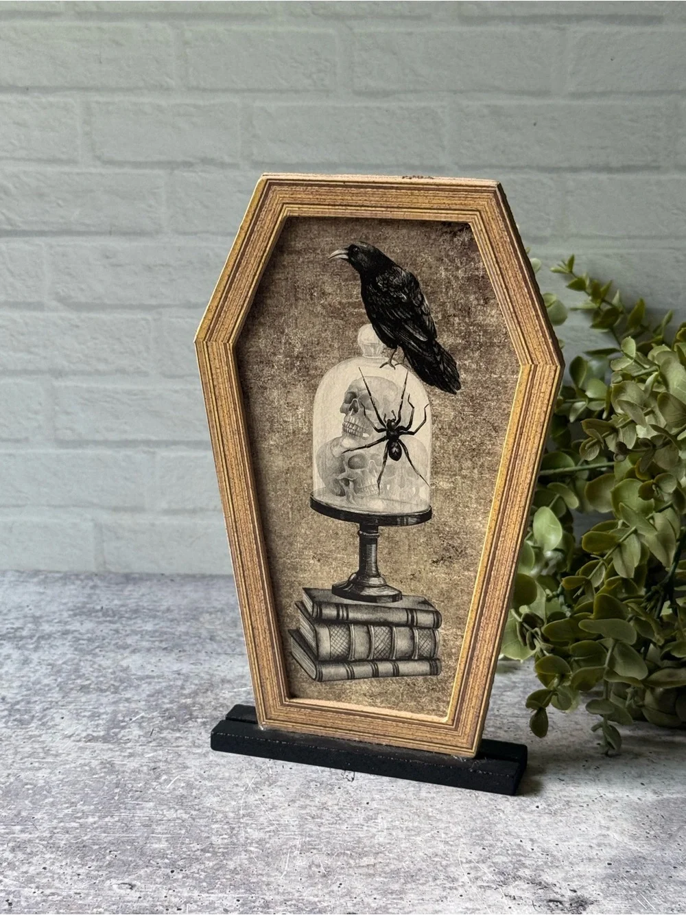 Coffin Shaped Halloween Decor with Crow, Skulls, Books, and Spider Illustration